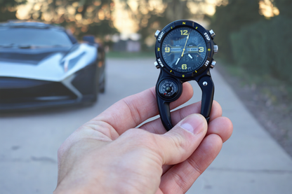 Clip watch with black case and black/yellow dial, featuring a digital display and analog features, with a built-in compass.